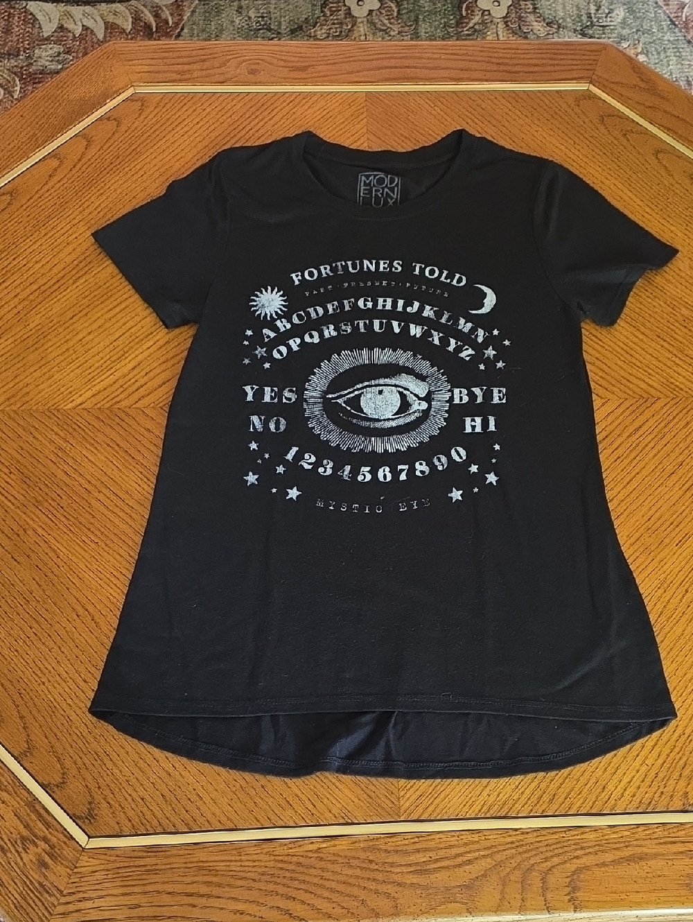 Modern Lux brand graphic tee featuring a ouija board design with "Fortunes Text